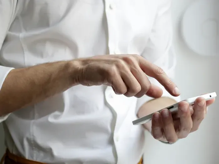 Closeup of hands using a smartphone to search a business directory, showing how customers find local services